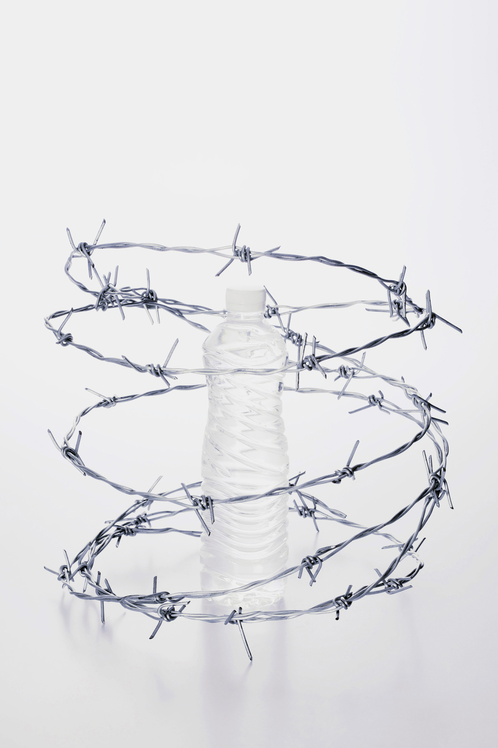 Plastic bottle surrounded by barbed wire